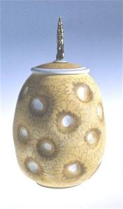 Campbell covered jar, 1984. Thrown and altered, airbrushed stain, glazed interior, no glaze on out side except on the stem. Over fired creating a pebble surface, C/6, gold lustre. Courtesy of the artist.