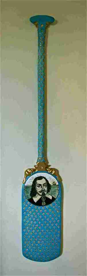 Keith Campbell. Artifact: The Samuel de Champlain Paddle. 125 cm L x 20 cm W x 4 cm D handbuilt and sculpted, stamped, stencil and painted, glaze with a clear glaze with stain under. Glued metal rods to join the 3 porcelain pieces together and gold paint. C/6 porcelain.