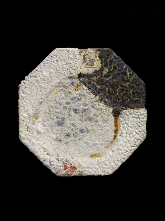 John Chalke. Beside Herself, Plate. Stoneware with volcanic glaze and transfers. Octagonal plate mostly covered with a grey volcanic glaze, with remaining smooth areas decorated with transfers of a woman's face . Signed 'John Chalke 1987'. 17.4 cm wide. Collection the Victoria and Albert Museum,