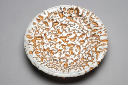 John Chalke. Round White, Orange, Black Mottled Wall Plate. 2000-1. 25.5x25.5x4.5 cm. fired clay and glaze. Collection of the Alberta Foundation for the Arts.