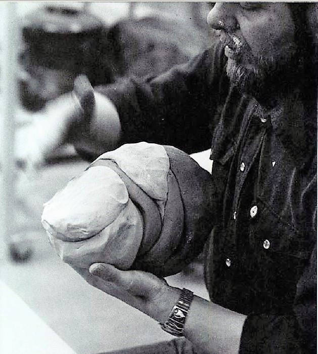 Les Manning. "Preparing to throw a multi-coloured object Les paddles wedged lumps of porcelain and stoneware into a uniform shape." Ceramics Monthly, June 1982.
