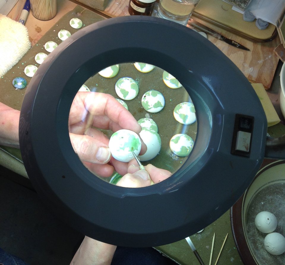 Pam Birdsall carving an earth pendant.