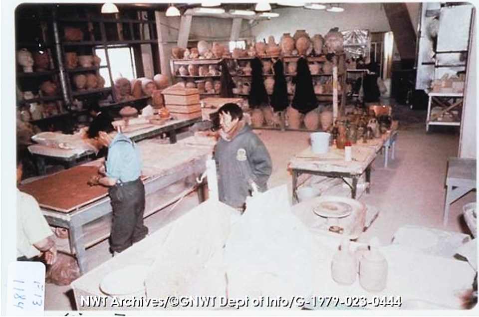 [Rankin Inlet, 1971, 3 men in pottery studio, with work tables and shelves of pots, heads and other clay figures.] CREDIT: NWT Archives/Northwest Territories. Department of Information fonds/G-1979-023: 0444